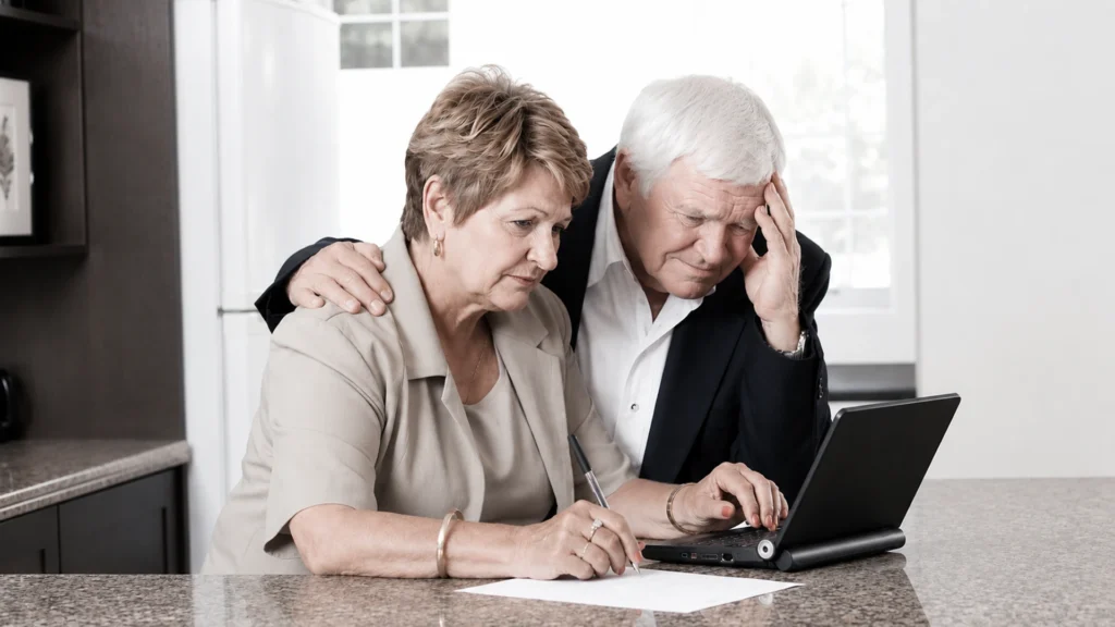 Un couple de seniors devant un écran d'ordinateur