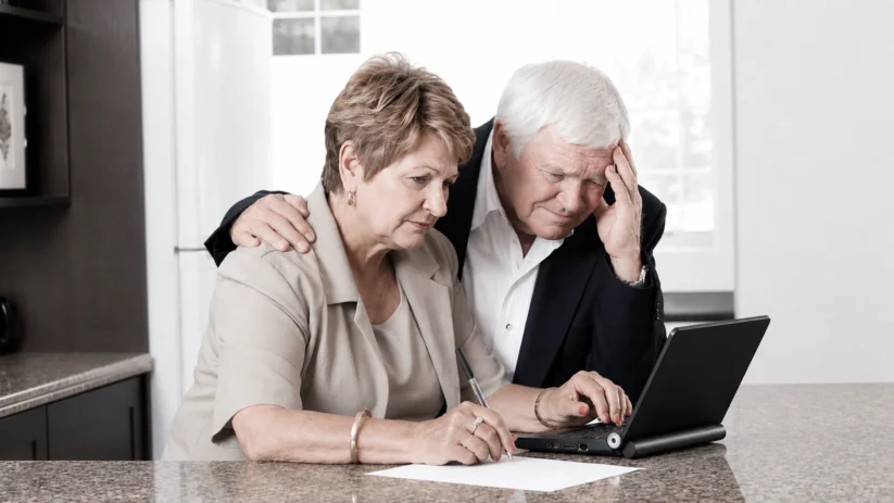 Un couple de seniors devant un écran d'ordinateur